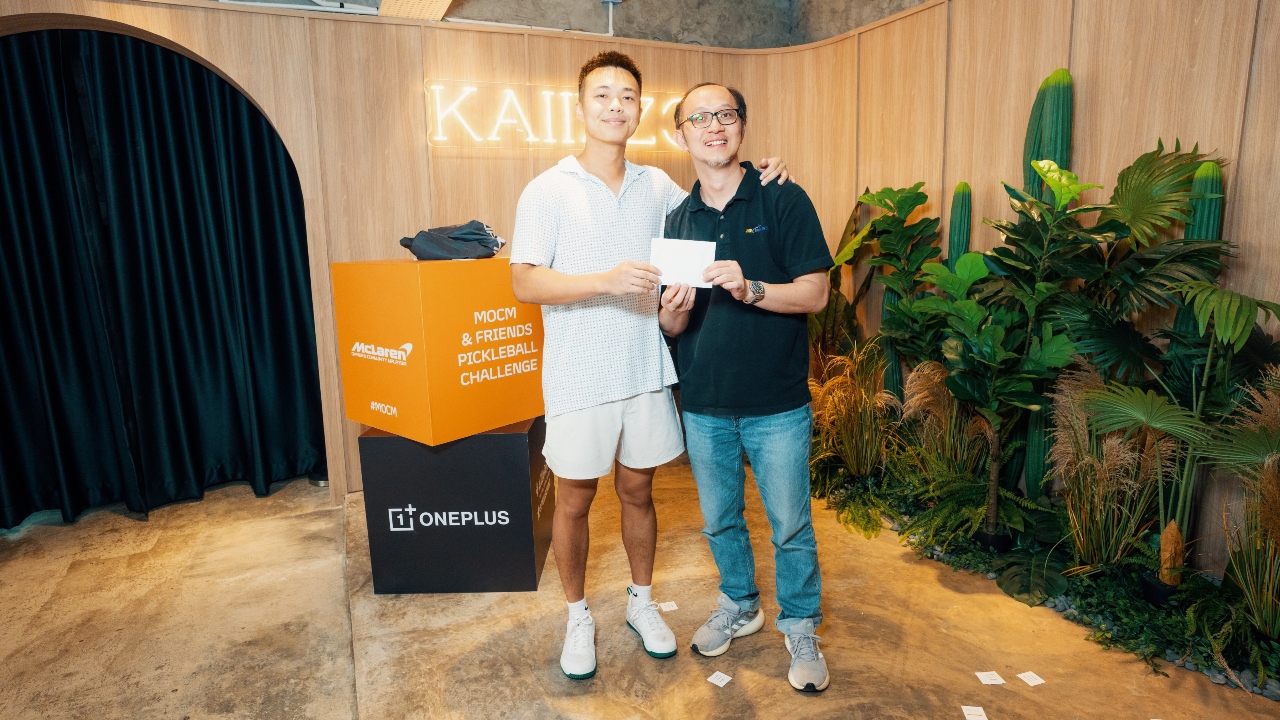 Eric Leong (left) receives the grand prize of a two-night stay at Amanjiwo from Jackson Lee of JNE Tour & Travel.