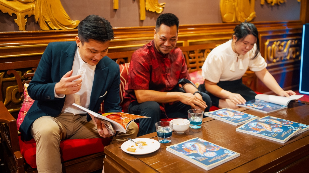 Kenny Fernandez of Johnnie Walker (centre) takes a closer look at the recent edition of Robb Report Malaysia.